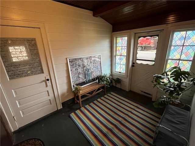 doorway to outside featuring wood ceiling, dark carpet, and beamed ceiling