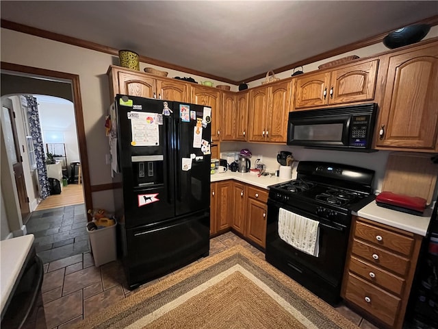 kitchen featuring light tile patterned floors, crown molding, and black appliances