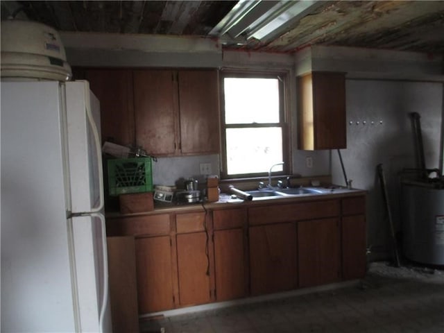 kitchen with sink, water heater, and white refrigerator