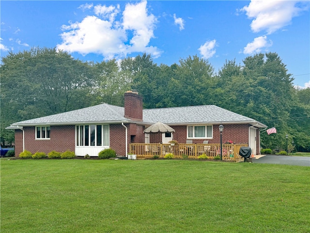 ranch-style house featuring a wooden deck and a front lawn