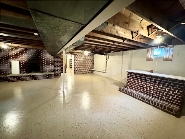 basement with a fireplace and brick wall