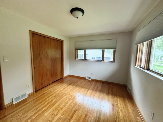 unfurnished bedroom featuring a closet and light hardwood / wood-style floors