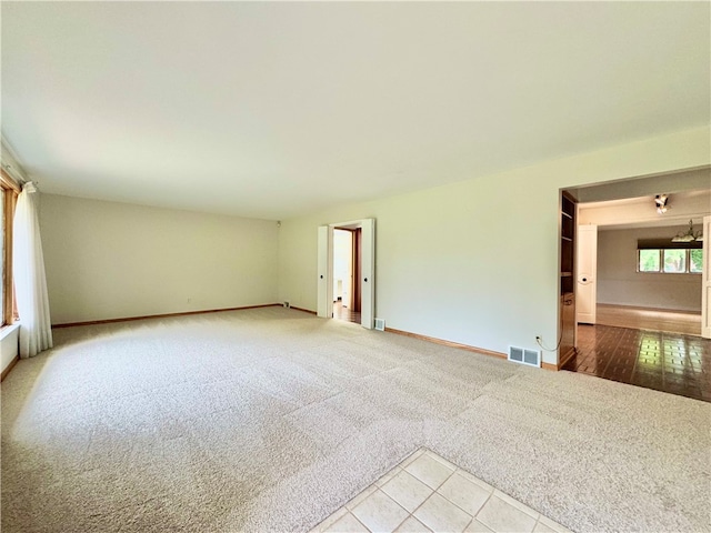 unfurnished room featuring light carpet