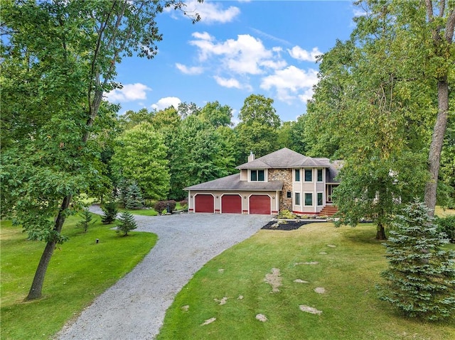 view of front facade with gravel driveway, an attached garage, a chimney, a front lawn, and stone siding