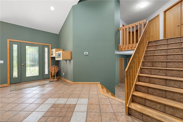 entrance foyer featuring light tile patterned flooring and high vaulted ceiling