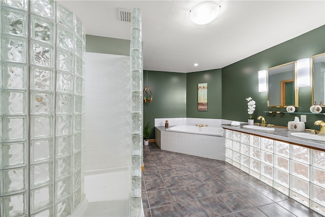 bathroom featuring tile patterned floors, dual vanity, and tiled bath