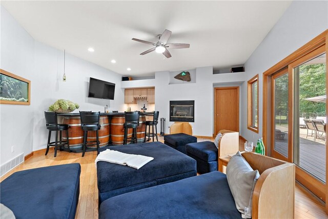 living room featuring ceiling fan and light hardwood / wood-style flooring