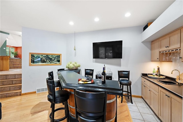 bar with stairs, recessed lighting, visible vents, and a sink