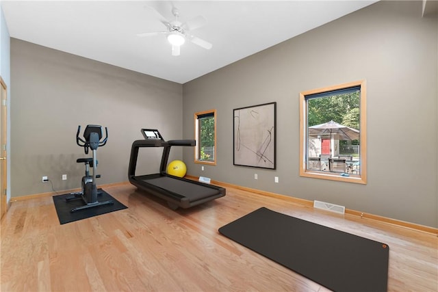 exercise room with visible vents, ceiling fan, baseboards, and wood finished floors