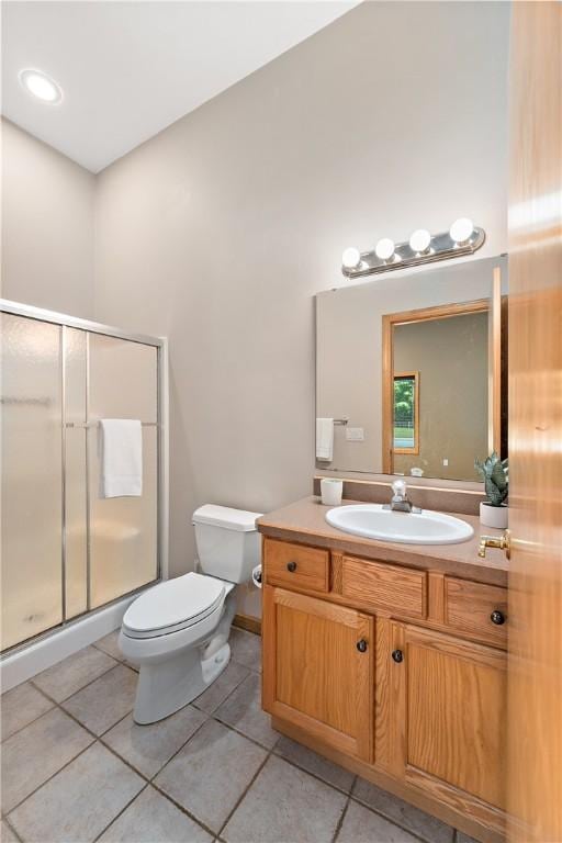 full bathroom featuring tile patterned floors, toilet, a stall shower, and vanity