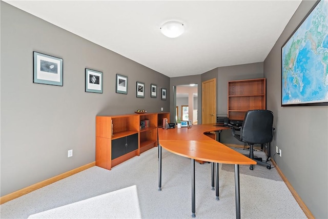 home office with baseboards and light colored carpet