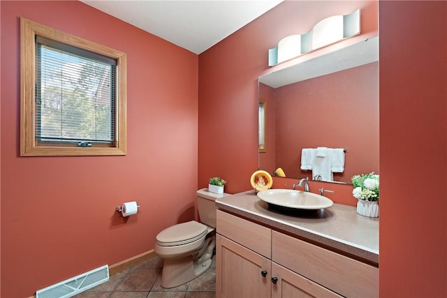 bathroom with tile patterned flooring, visible vents, baseboards, toilet, and vanity