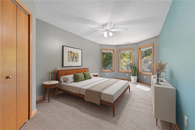 bedroom featuring ceiling fan, a closet, and a textured ceiling