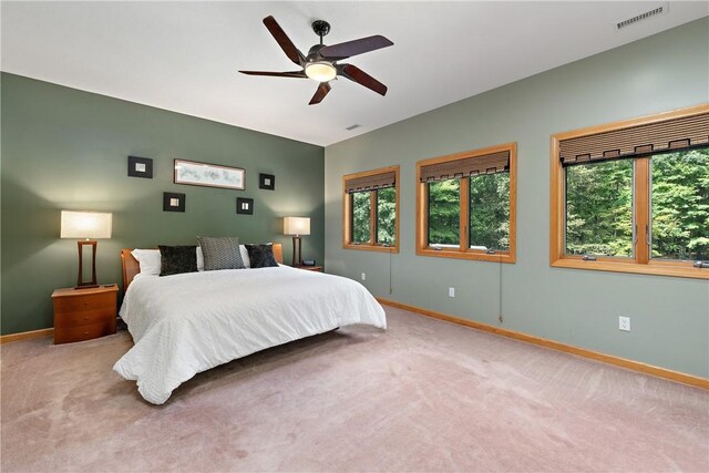 bedroom featuring multiple windows, carpet, and ceiling fan