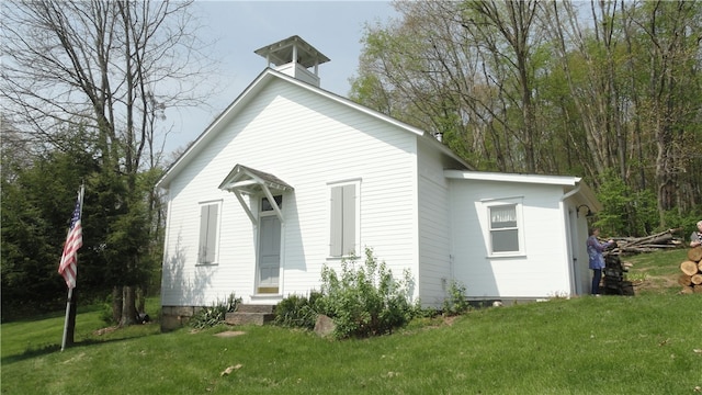 rear view of house featuring a lawn