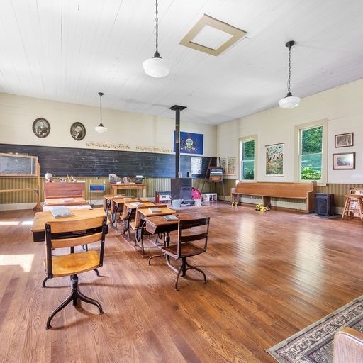 dining area with hardwood / wood-style flooring and wooden walls