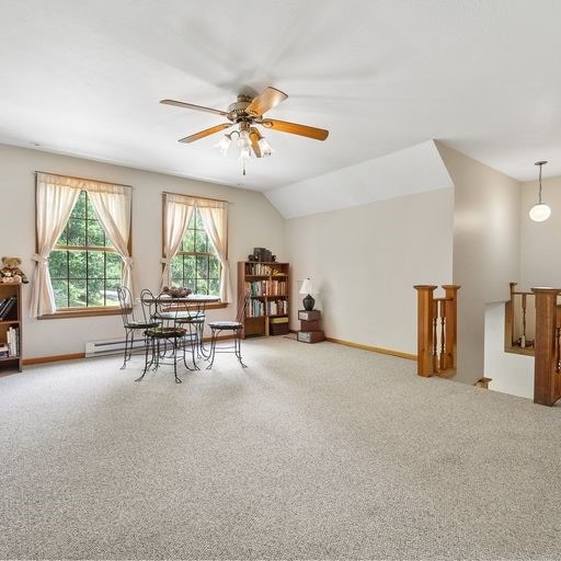 interior space with ceiling fan, carpet, and lofted ceiling