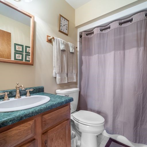 bathroom with vanity, toilet, walk in shower, and tile patterned flooring