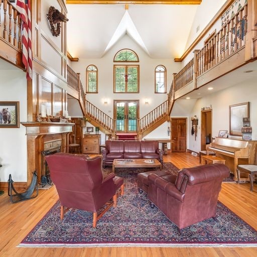 living room with high vaulted ceiling and wood-type flooring