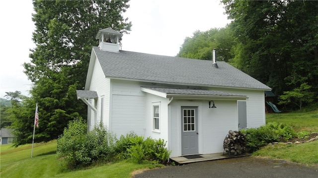 view of outbuilding with a playground and a lawn