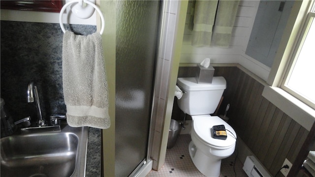 bathroom featuring a baseboard heating unit, walk in shower, toilet, wooden walls, and tile patterned flooring