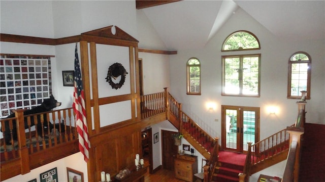 staircase with french doors, hardwood / wood-style flooring, high vaulted ceiling, and beamed ceiling