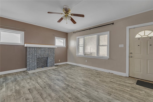 unfurnished living room featuring light hardwood / wood-style floors, ceiling fan, and a fireplace