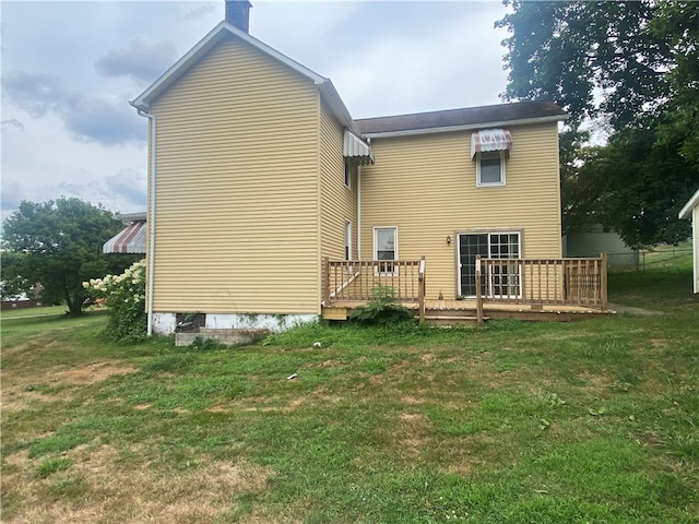 back of house with a wooden deck and a lawn