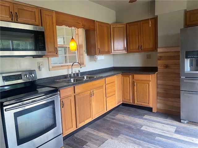 kitchen with dark wood-type flooring, sink, hanging light fixtures, ceiling fan, and stainless steel appliances