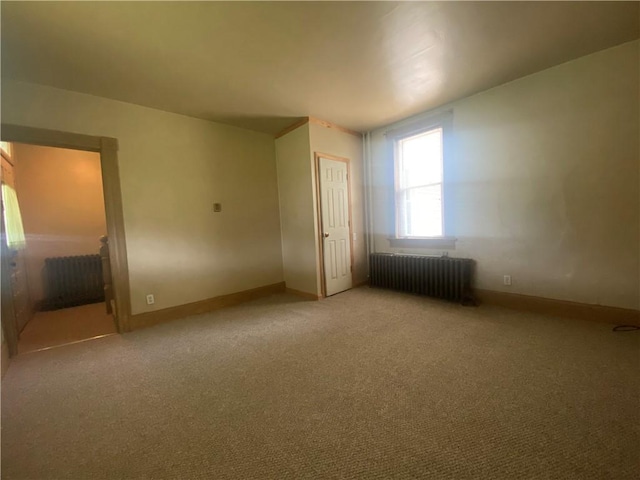 unfurnished bedroom with radiator heating unit, carpet flooring, and a closet