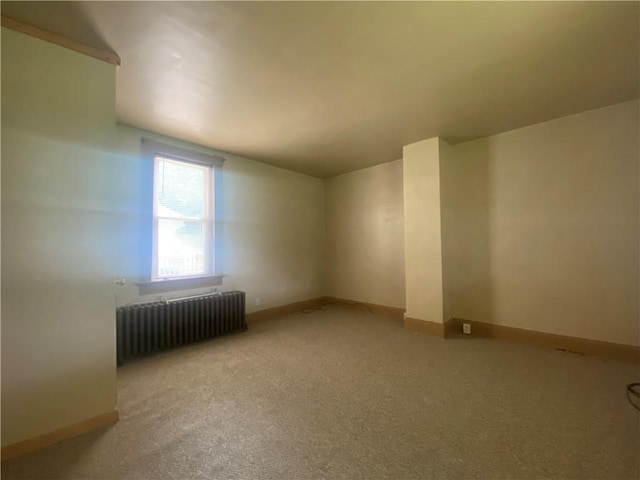 bonus room with radiator heating unit and carpet flooring