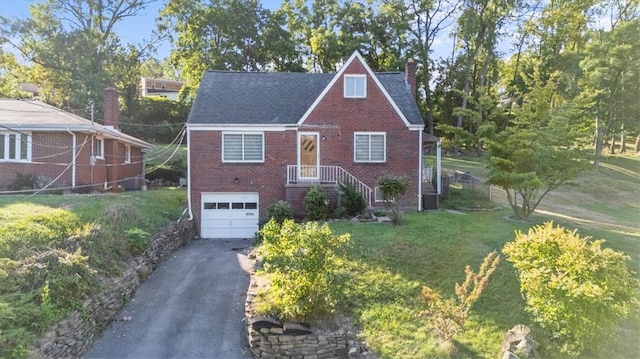 view of front of property with a front lawn, central AC unit, and a garage