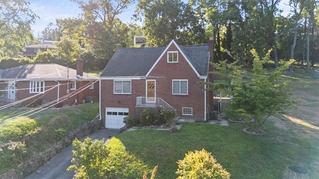 view of front of property featuring a garage, central AC unit, and a front yard