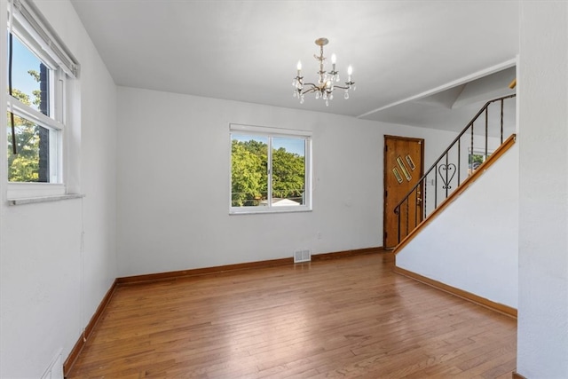 interior space with hardwood / wood-style floors, a healthy amount of sunlight, and a chandelier