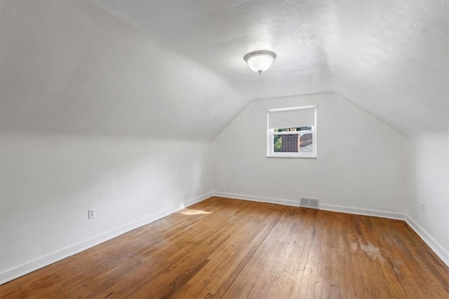 bonus room featuring hardwood / wood-style floors and lofted ceiling