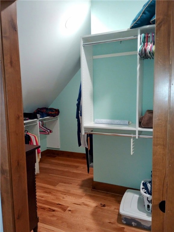 spacious closet featuring light wood-type flooring and vaulted ceiling