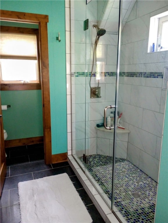 bathroom featuring a wealth of natural light, toilet, walk in shower, and tile patterned floors