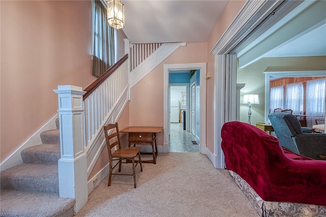 staircase with carpet and a notable chandelier