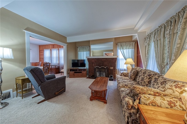 carpeted living room with a healthy amount of sunlight and a brick fireplace