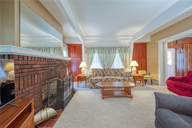 living room with carpet floors, a brick fireplace, and wood walls