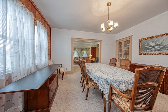 dining room featuring a chandelier and light colored carpet