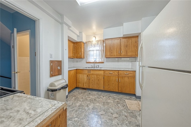 kitchen featuring sink, decorative backsplash, white refrigerator, and light tile patterned floors