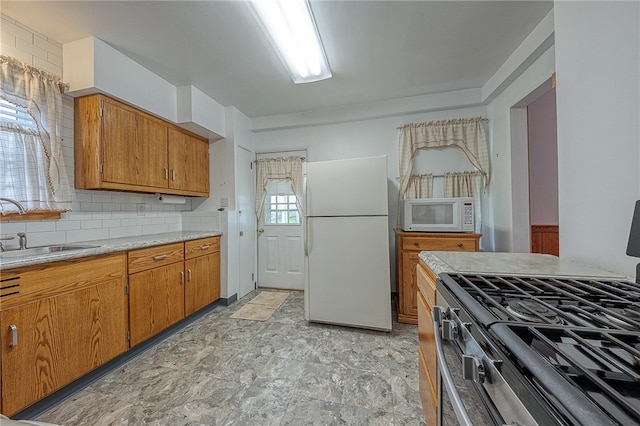 kitchen featuring light tile patterned floors, backsplash, sink, and white appliances