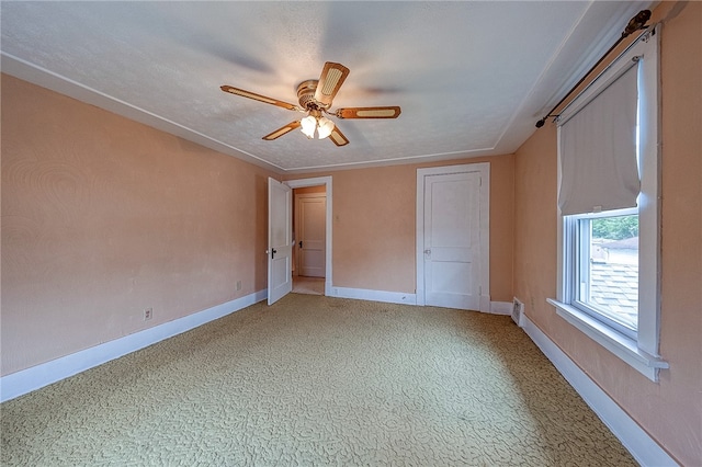 unfurnished bedroom with ceiling fan, carpet, and a textured ceiling