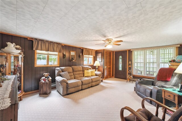 carpeted living room featuring ceiling fan and wooden walls