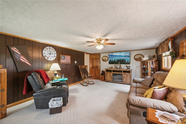 carpeted living room with ceiling fan, a fireplace, and wood walls