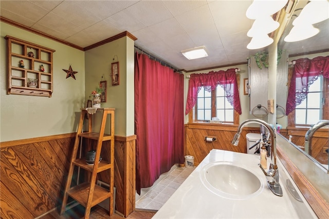 bathroom with wooden walls, crown molding, vanity, and tile patterned floors