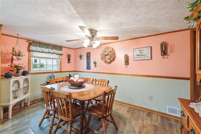 dining space featuring ceiling fan, hardwood / wood-style flooring, and a textured ceiling