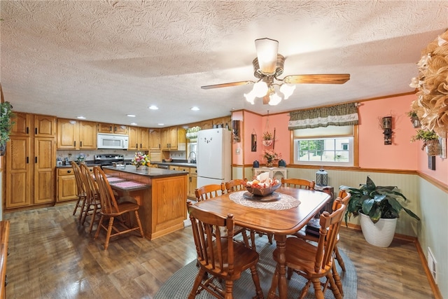 dining area featuring dark hardwood / wood-style flooring, a textured ceiling, and ceiling fan