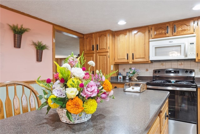 kitchen with tasteful backsplash, stainless steel electric stove, and a textured ceiling